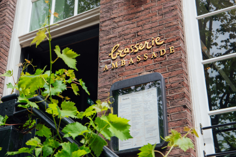 Facade of Brasserie Ambassade in Amsterdam with menu on display